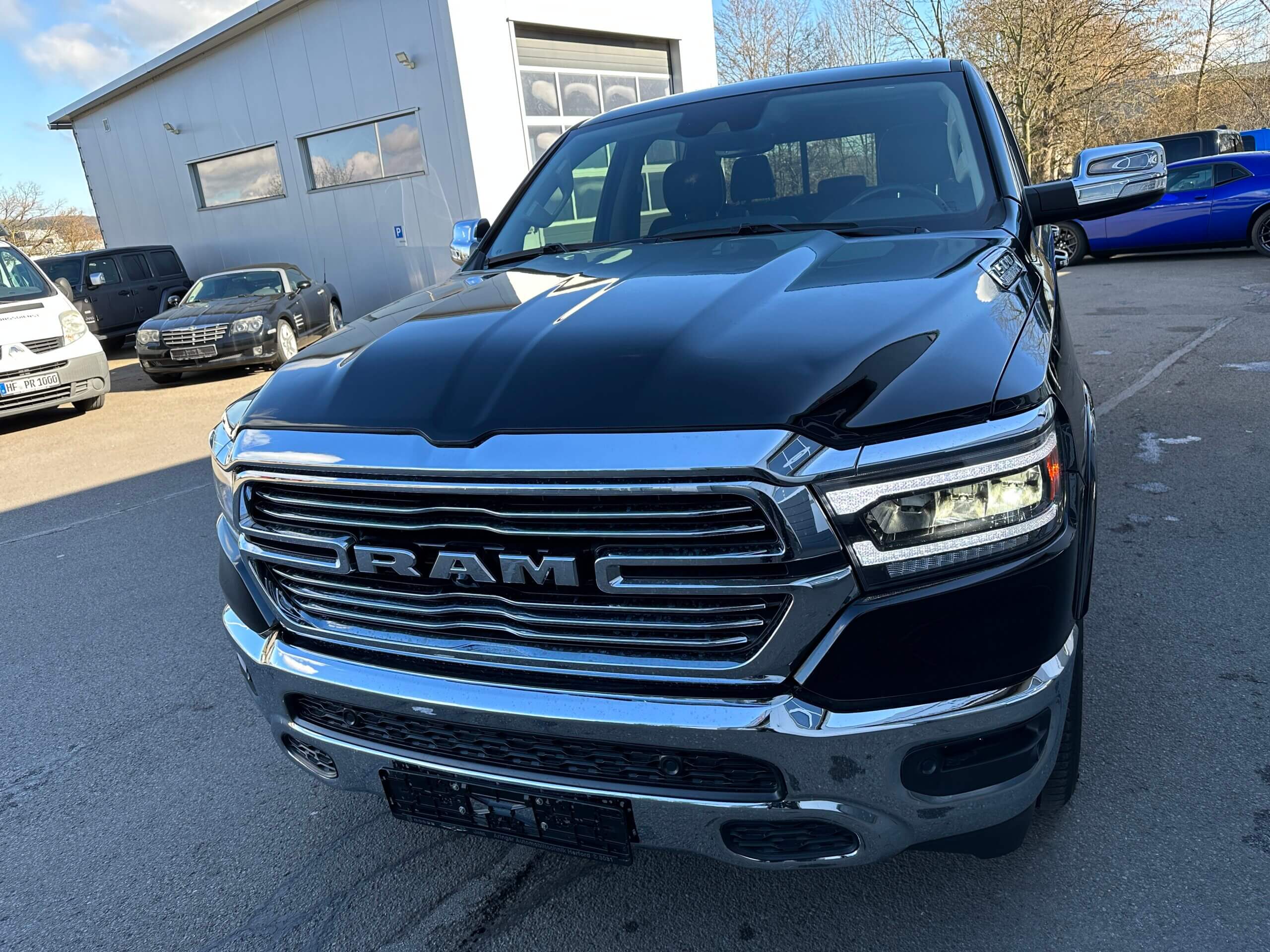 Ein schwarzer RAM-Pickup mit markantem Chrom-Kühlergrill auf einem Parkplatz